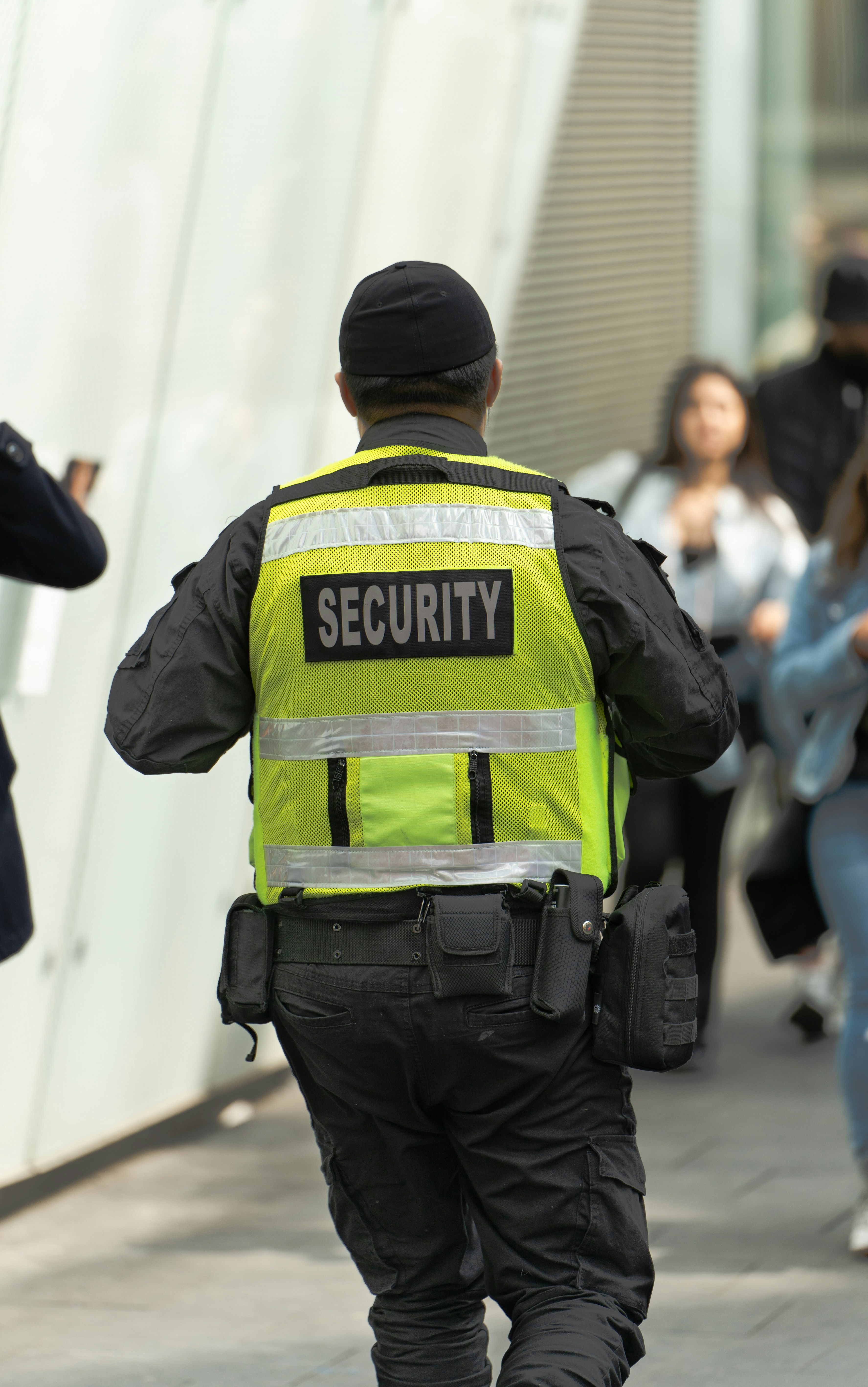 Security guard in hi-vis vest patrolling a commercial area