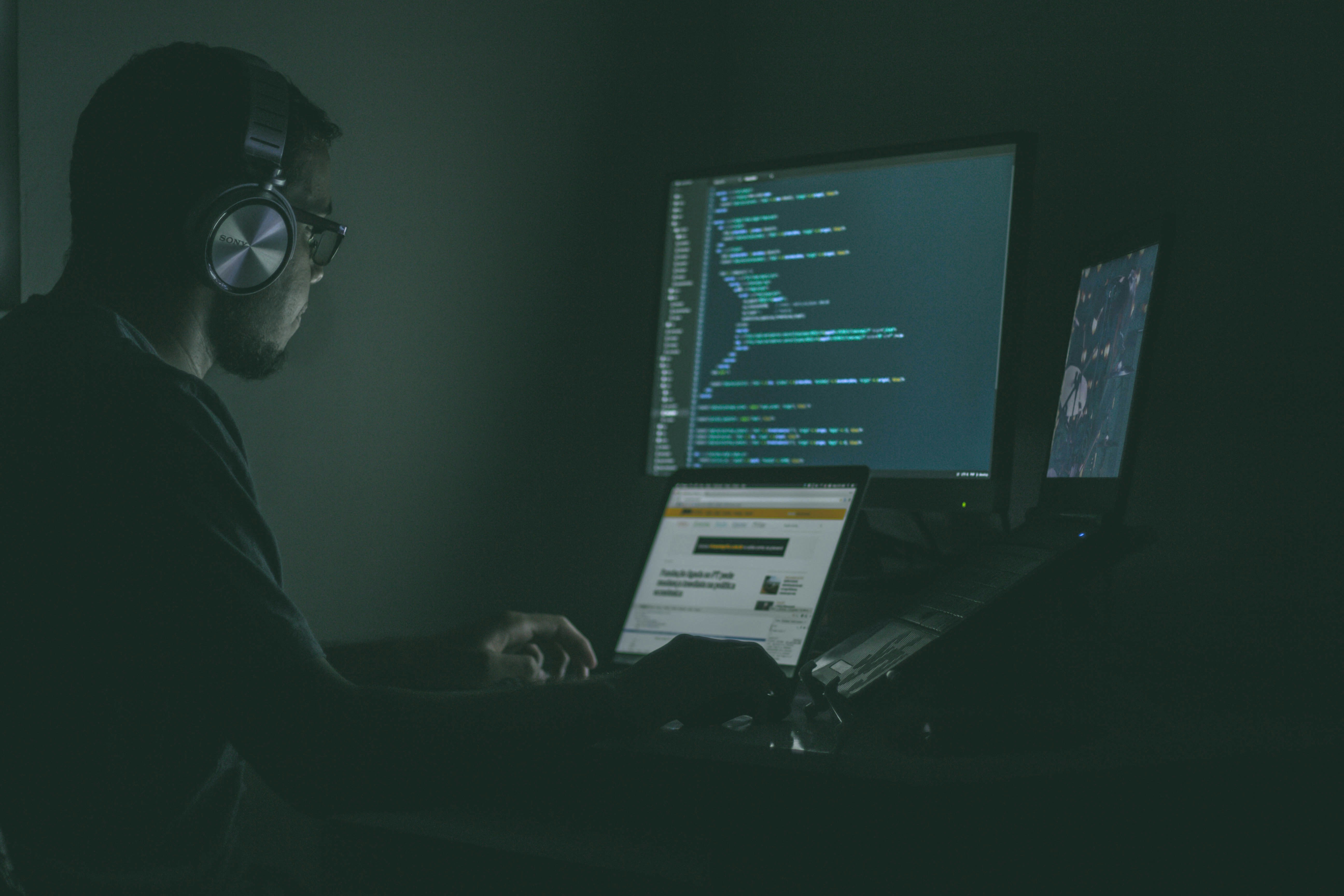 Security analyst at a multi-screen monitoring station
